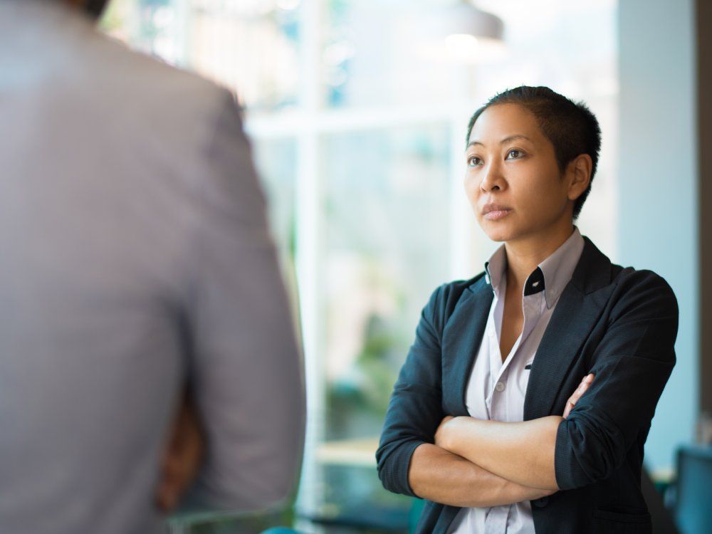 Tense Asian businesswoman looking at male partner