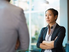 Tense Asian businesswoman looking at male partner