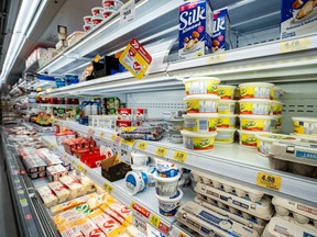 Dairy and refrigerated products are displayed in a grocery cooler aisle in Brampton, Nov. 16, 2025.