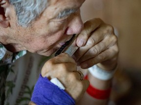 Neal Tomita, 79, plays the harmonica during a virtual class for people with Parkinson's disease and their care partners.