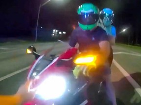 Florida sheriff's deputy is seen approaching a motorcyclist during a traffic stop.