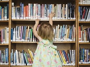 Girl in library reaching for book