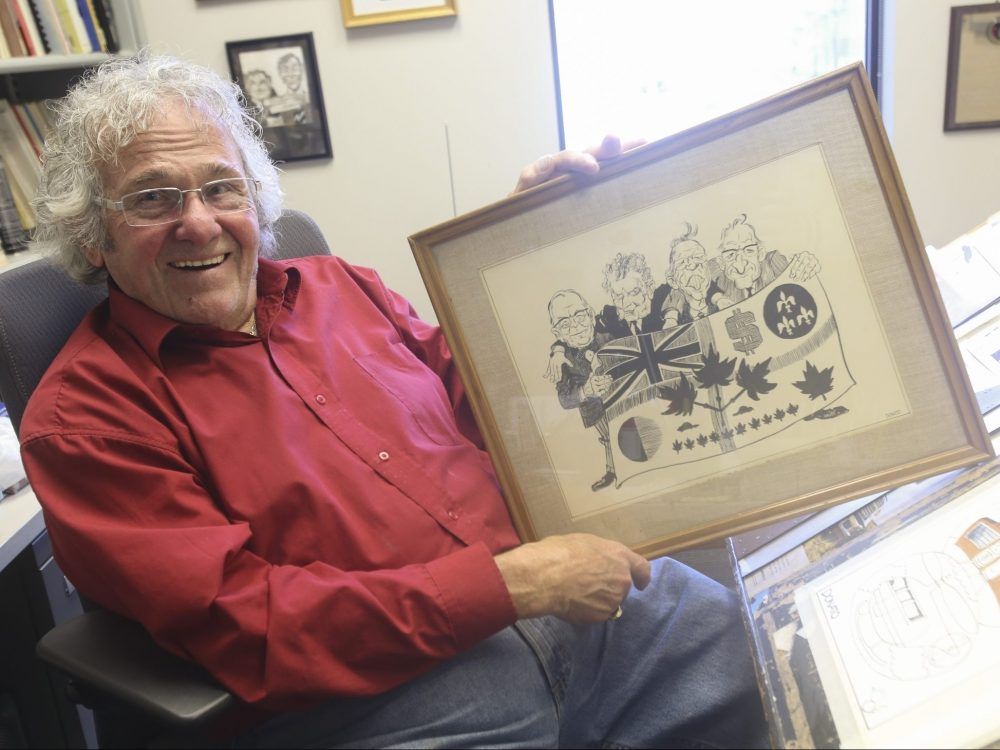 Editorial cartoonist Andy Donato poses in 2014 with the first editorial cartoon he created for the Toronto Telegram.