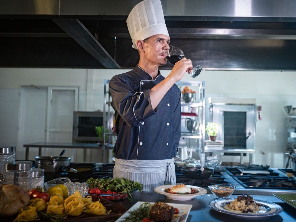 A chef with a glass of wine