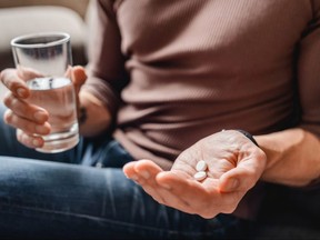 A man takes medicine with water