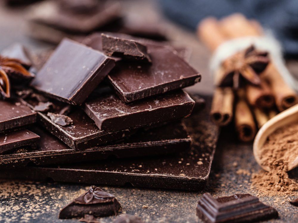 Chocolate bar pieces. Background with chocolate. Sweet food photo concept. The chunks of broken chocolate