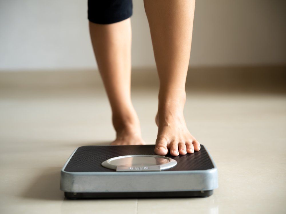 Female leg stepping on weigh scales. Healthy lifestyle, food and sport concept.