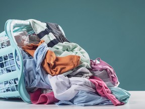 Heap of dirty clothes and laundry basket