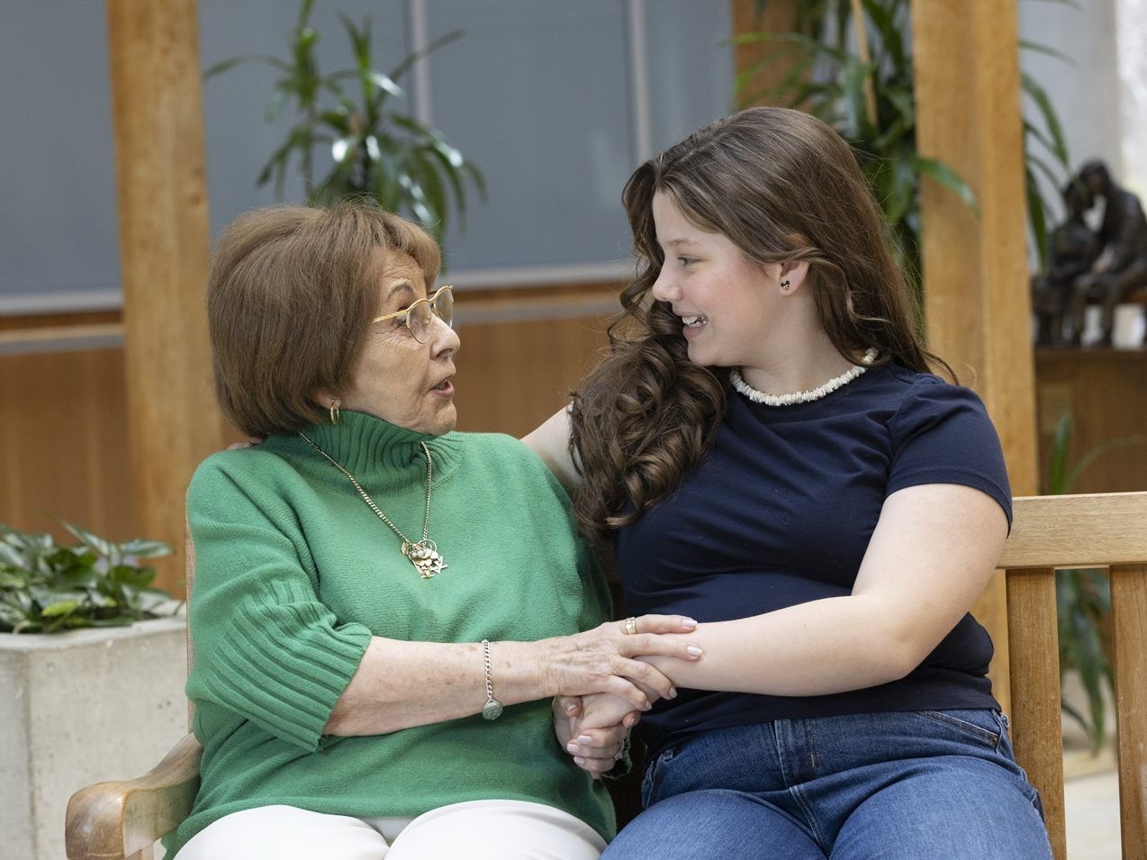 An elderly woman talking to a younger woman on a couch.