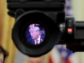 U.S. President Donald Trump is seen in the electronic viewfinder of a television camera as he speaks to reporters.