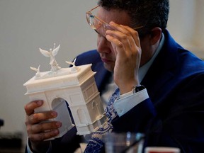 Commission of Fine Arts commission member Matthew Taylor inspects a model of U.S. President Donald Trump's proposed triumphal arch to commemorate the country's 250th anniversary during a public meeting of the Commission of Fine Arts at the National Building Museum on April 16, 2026 in Washington, D.C.