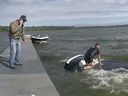 A New York State trooper is seen atop a sinking vehicle in a lake in upstate New York.
