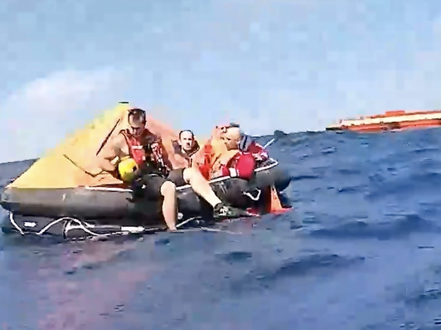 Passengers that evacuatged a research vessel following an engine room fire are pictured on a lifeboat.