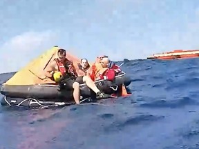 Passengers that evacuatged a research vessel following an engine room fire are pictured on a lifeboat.