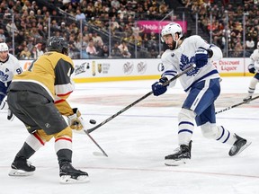 Kirill Marchenko of the Toronto Maple Leafs takes a shot against Rasmus Andersson of the Vegas Golden Knights.
