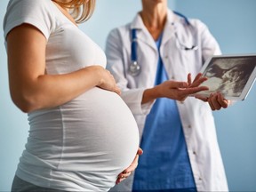 A doctor explains ultrasound scan results to a pregnant woman.