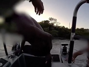 A man is seen being helped aboard a deputy's boat during a rescue captured on camera.