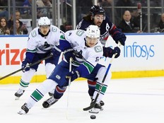 Mika Zibanejad of the New York Rangers checks Aatu Räty of the Vancouver Canucks.