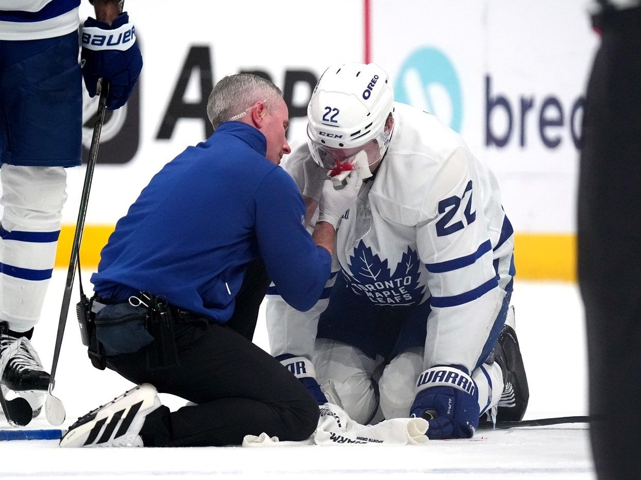 A member of the Toronto Maple Leafs staff attends to Jake McCabe of the Toronto Maple Leafs.