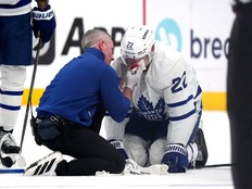 A member of the Toronto Maple Leafs staff attends to Jake McCabe of the Toronto Maple Leafs.