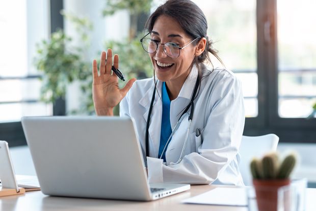 Shot of female doctor waving and talking with colleagues during a video call. MedExpress says that 83% of Canadian rural residents would prefer virtual health care, as opposed to 73% residing in an urban setting.