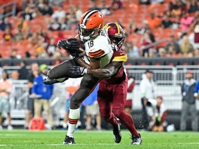 David Bell #18 of the Cleveland Browns catches a seven-yard touchdown against Jartavius Martin #20 of the Washington Commanders during the second half of a preseason game at Cleveland Browns Stadium on August 11, 2023 in Cleveland, Ohio.