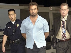 Max Factor fortune heir Andrew Luster is brought out of the Los Angeles International Airport under the custody of airport police and FBI agents after his arrival from Puerto Vallarta Mexico 19 June, 2003.