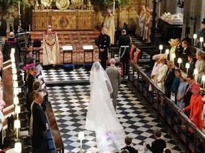 Prince Harry looks at his bride, Meghan Markle, as she arrived accompanied by Prince Charles, Prince of Wales during their wedding in St George's Chapel at Windsor Castle on May 19, 2018 in Windsor, England.