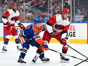 Oilers captain Connor McDavid battles for the puck against Jesperi Kotkaniemi of the Hurricanes during first period NHL action at Rogers Place in Edmonton, Thursday, Oct. 22, 2026.