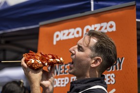 Jason Sheardown, Director of Culinary & Product Innovation at Pizza Pizza with a Pizza Pizza deep fried slice at the CNE Media Preview Day in Toronto on Wednesday August 19, 2026.