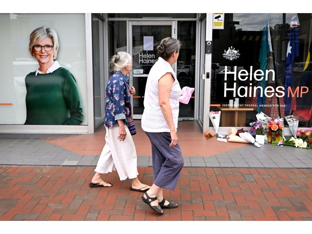 People lay flowers outside the office of Australian politician Helen Haines in the northern regional city of Wangaratta, some 250 kilometres north-east of Melbourne on October 20, 2026. Australian independent lawmaker Helen Haines underwent surgery overnight but remains in a critical condition after being struck deliberately by a car in an attack, Prime Minister Anthony Albanese said on October 20. (William WEST/AFP)
