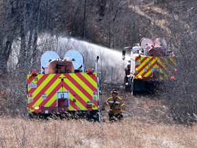 Canadian Forces fire trucks extinguish hot spots on the edge of Canadian Forces Base Wainwright on October 18, 2026. The blaze initially spread quickly, killing several soldiers and injured dozens more during a training exercise on Saturday afternoon.