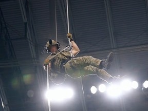 A military member rappels from the stadium rafters in a previous demonstration.