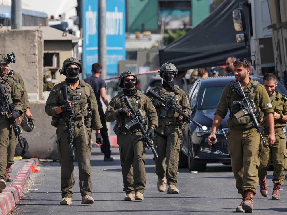 Israeli soldiers gather at the scene of an earlier fire exchange between armed Palestinians and Israeli forces following an incident at the northern checkpoint of Hebron in the Israeli-occupied West Bank on Oct. 23, 2026.