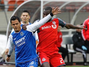 FC Edmonton player Kyle Yamada plays the ball around Toronto FC player Tony Tchani during their game at Commonwealth Stadium on Wednesday. (Perry Nelson, Edmonton Sun)