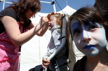 (Left to right) Her face already painted Kalyn Galloway, 6, (right) waits as her sister Haylee Galloway, 4, has her face painted by Ashlie Parenteau at the Fantastical Face Painting booth, during the Rainmaker Rodeo in St. Albert, Saturday May 28, 2011. (DAVID BLOOM/EDMONTON SUN)