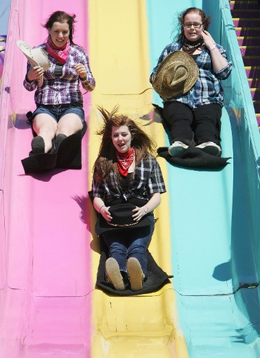 (Left to right) Holding on to their cowboy hats Emily Picard, 17, Melissa Marchand, 16, and Carly Mollan, 16, ride the super slide during the Rainmaker Rodeo in St. Albert, Saturday May 28, 2011. (DAVID BLOOM/EDMONTON SUN)