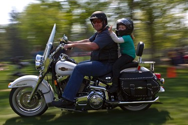 Mark Wesley gives Emily Gamble, 6, a ride on his motorcycle at Hawrelak Park in Edmonton on Sunday, May 29, 2011. Bikers gathered to give rides to children in support of Kids With Cancer. (CODIE MCLACHLAN/EDMONTON SUN)