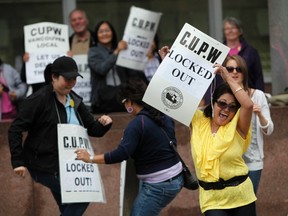 Canadian Union of Postal Workers (CUPW) members dance during a protest outside the building of Canada Post's Vancouver Main Post Office in downtown Vancouver, British Columbia, June 17, 2011. REUTERS/Jason Lee