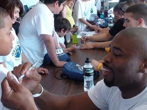 Chicago Bears defensive end Israel Idonije signs a boy’s shirt at his fifth annual all-star camp for under-privileged kids Saturday at Winnipeg Indoor Soccer Complex. The sixth annual camp takes place Saturday, June 16, 2012.