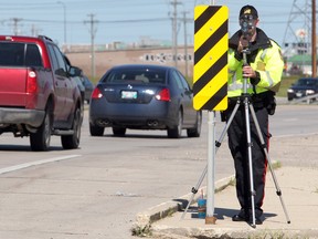 A Winnipeg police officer checks for speeders on Bishop Grandin Boulevard. (BRIAN DONOGH/Winnipeg Sun)