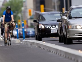 A cyclist tries out the new segregated bike lane on Laurier Ave. after it was opened on Sunday. (Errol McGihon, Ottawa Sun)