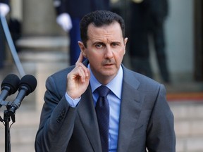 Syria’s President Bashar al-Assad gestures as he takes questions from journalists after a meeting at the Elysee Palace in Paris in this December 9, 2010 file photo.  (REUTERS/Benoit Tessier/Files)