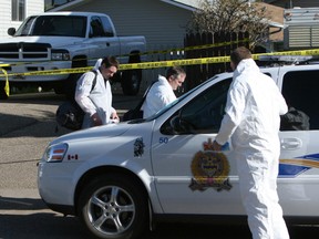Medicine Hat forensics team gets suited up Monday morning to go into the house on Cameron Road in Medicine Hat where a family was slain. (File photo THE CALGARY SUN)
