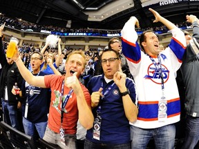 Winnipeg Jets fans celebrate during the season opener against the Montreal Canadiens on Sunday at MTS Centre.