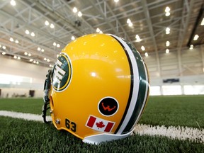 An Edmonton Eskimos helmet with a Grande Prairie Warriors football team logo.