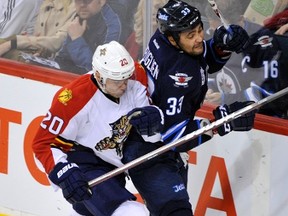 Winnipeg's Dustin Byfuglien is rubbed out along the boards by Florida's Sean Bergenheim on Thursday night at MTS Centre.
