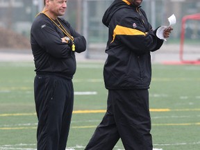 A CFL source on Saturday night said the Bombers, who fired CEO Garth Buchko and general manager Joe Mack on Friday and hired Wade Miller as acting CEO, will be bringing in former Hamilton Tiger-Cats head coach Marcel Bellefeuille (left, with Khari Jones on right) as a consultant.