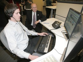 Mayor Sam Katz gets help from 311 staffer Robert Johnston when the centre launched in 2009. (Winnipeg Sun files)