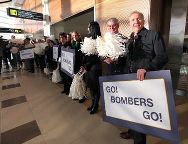 Winnipeg Blue Bombers fans and airport staff -- including Winnipeg Airports Authority president and CEO Barry Rempel -- cheer as players prepared to leave Winnipeg Richardson International Airport to play in the CFL Grey Cup in Vancouver. (JASON HALSTEAD, Winnipeg Sun)